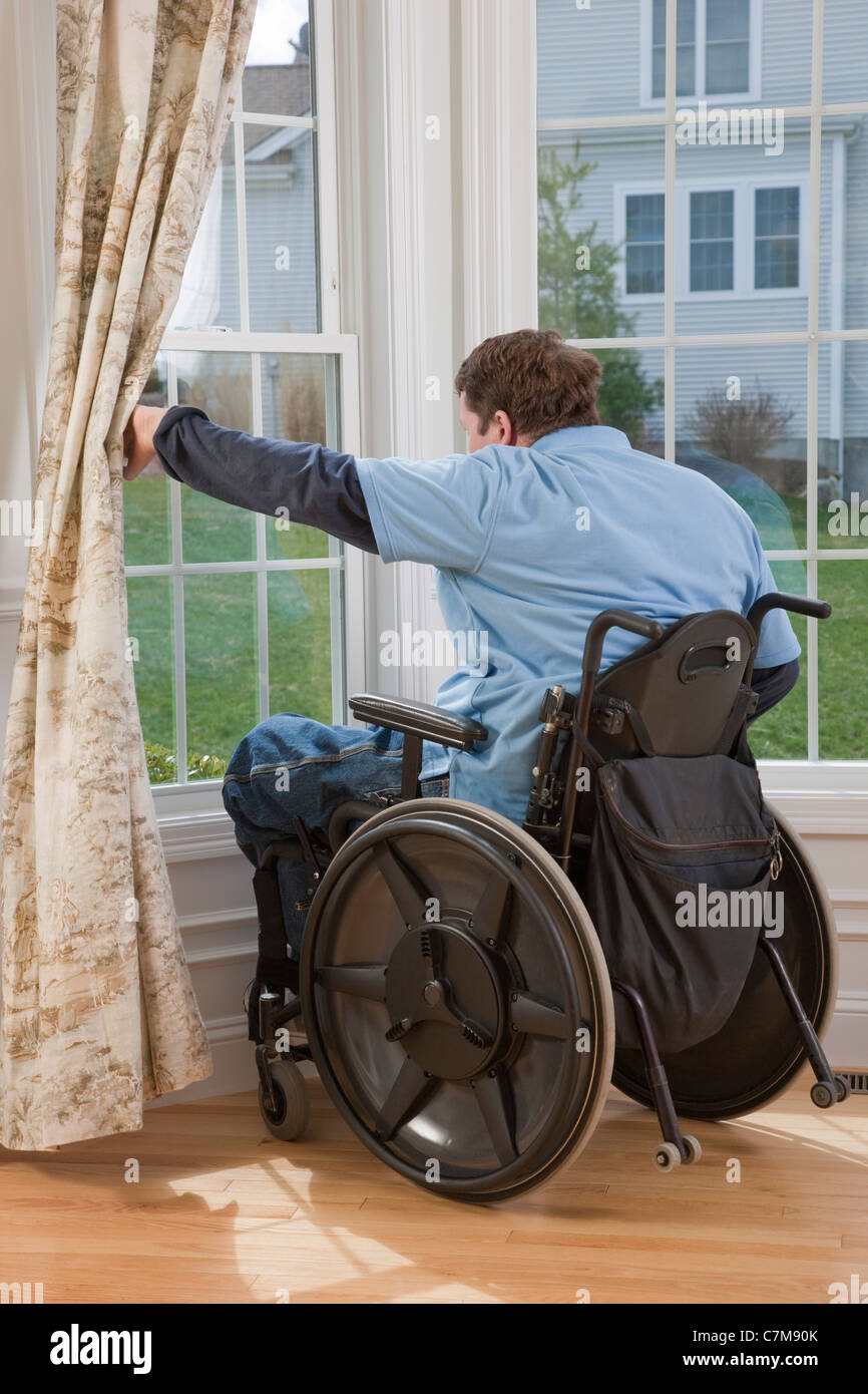 Man with spinal cord injury in a wheelchair looking out the window of