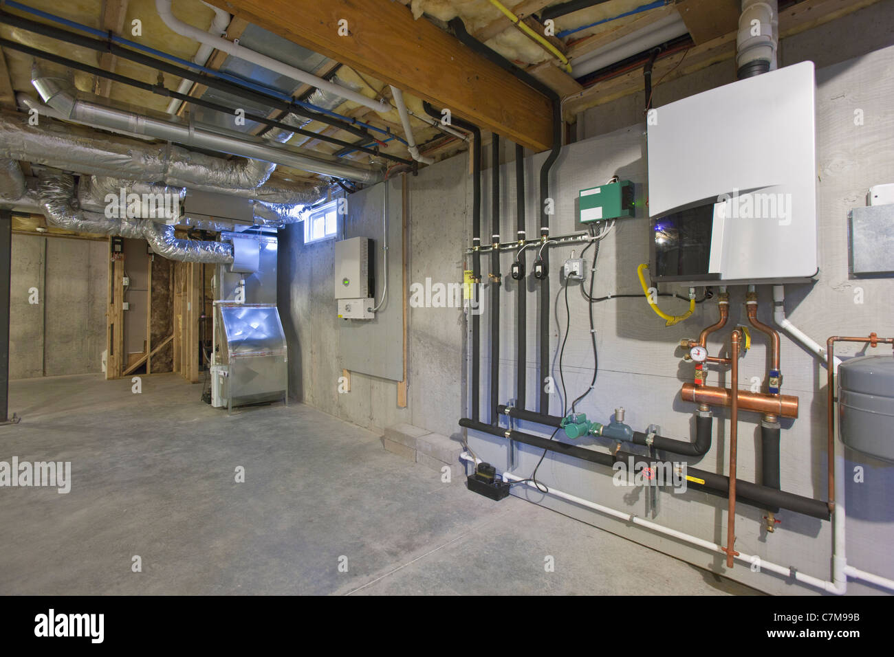 Heating and A/C system, photovoltaic inverter, and tankless hot water system in the basement of a Green Technology Home Stock Photo