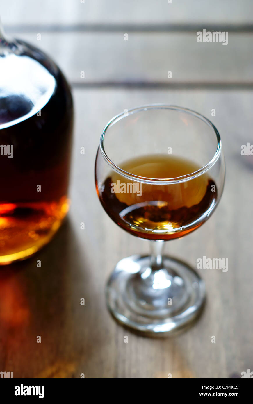 A bottle of alcohol or liquor and a measure in a glass equivalent to one unit of alcohol Stock Photo