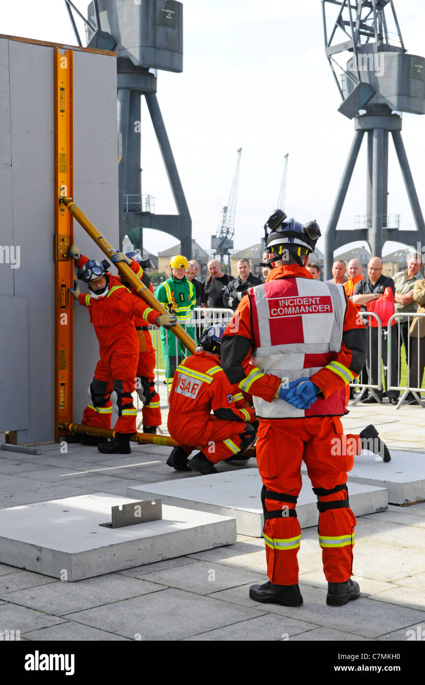 Urban Search & Rescue Fire Brigade teams competing & being assessed at UK Rescue Challenge event erecting temp shoring units Excel Centre London UK Stock Photo