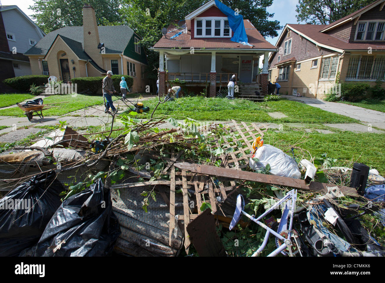 Detroit, Michigan - Members of the Three Mile Drive block club clean trash from a vacant home in their neighborhood. Stock Photo