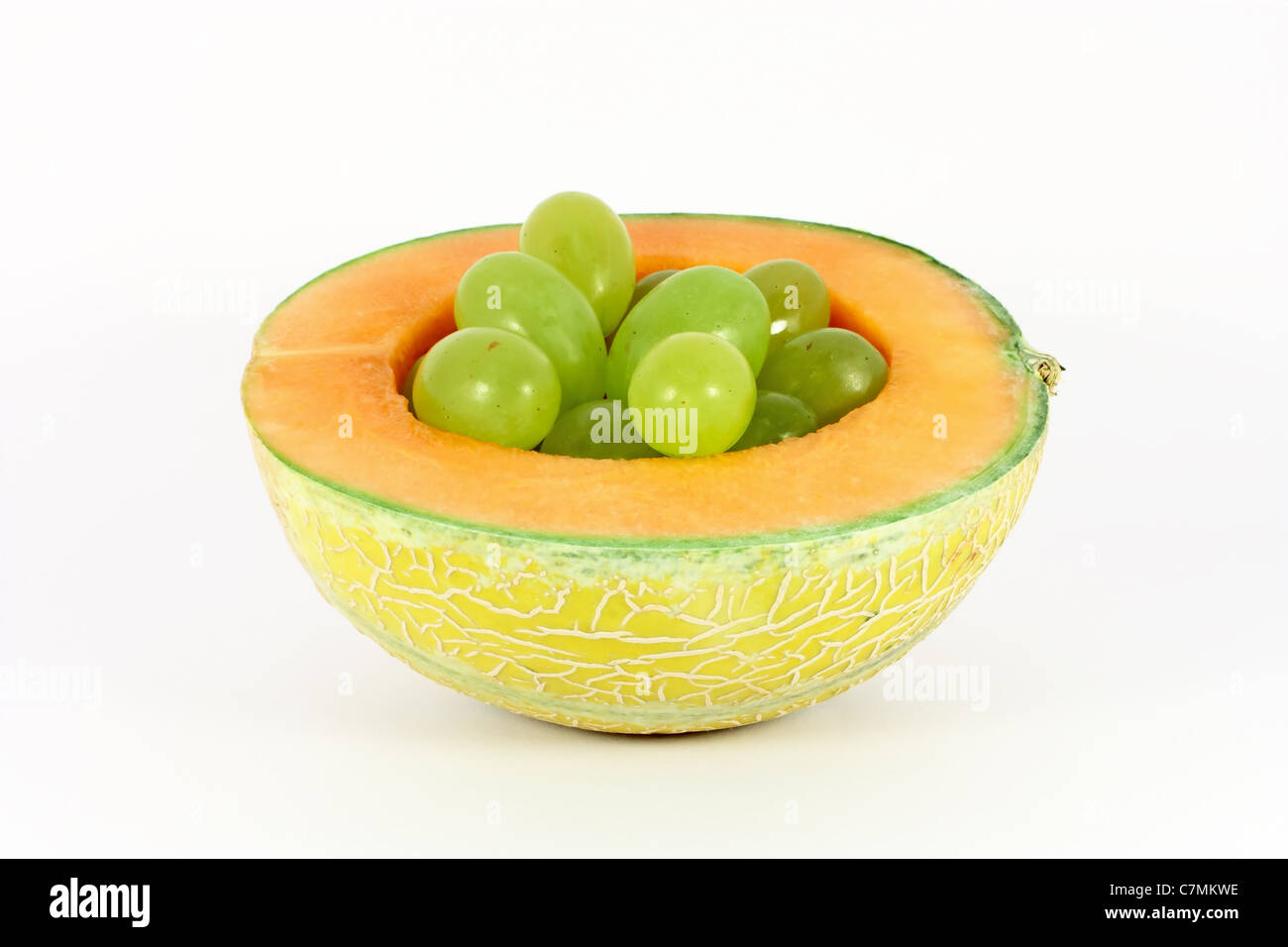 Grapes in a hole of melon isolated on white Stock Photo Alamy
