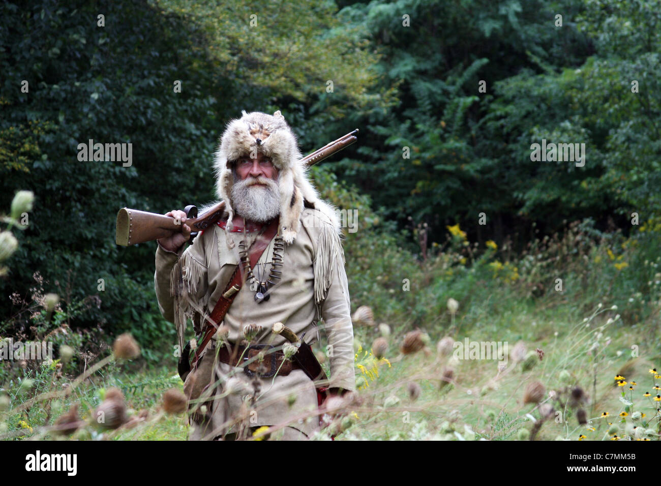 A hunter witha fox fur hat hunting in the woods Stock Photo Alamy