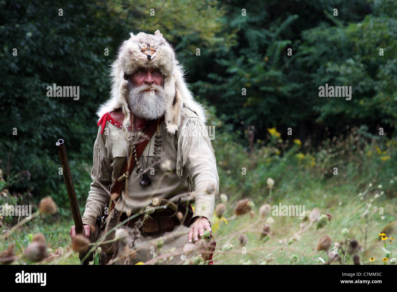 A hunter with a fox fur hat hunting in the woods Stock Photo Alamy