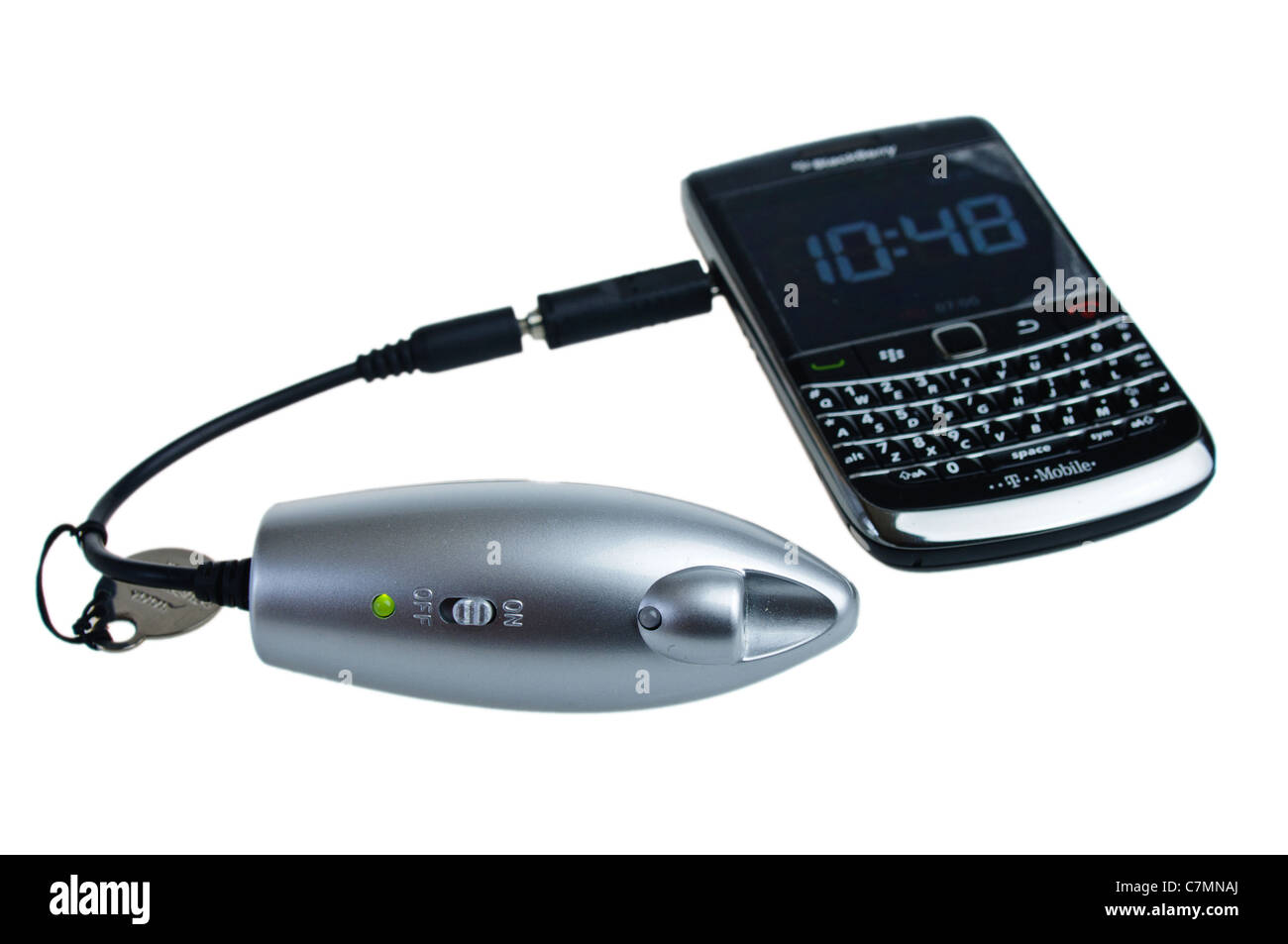 Powermonkey portable charger charging a Blackberry mobile phone Stock Photo