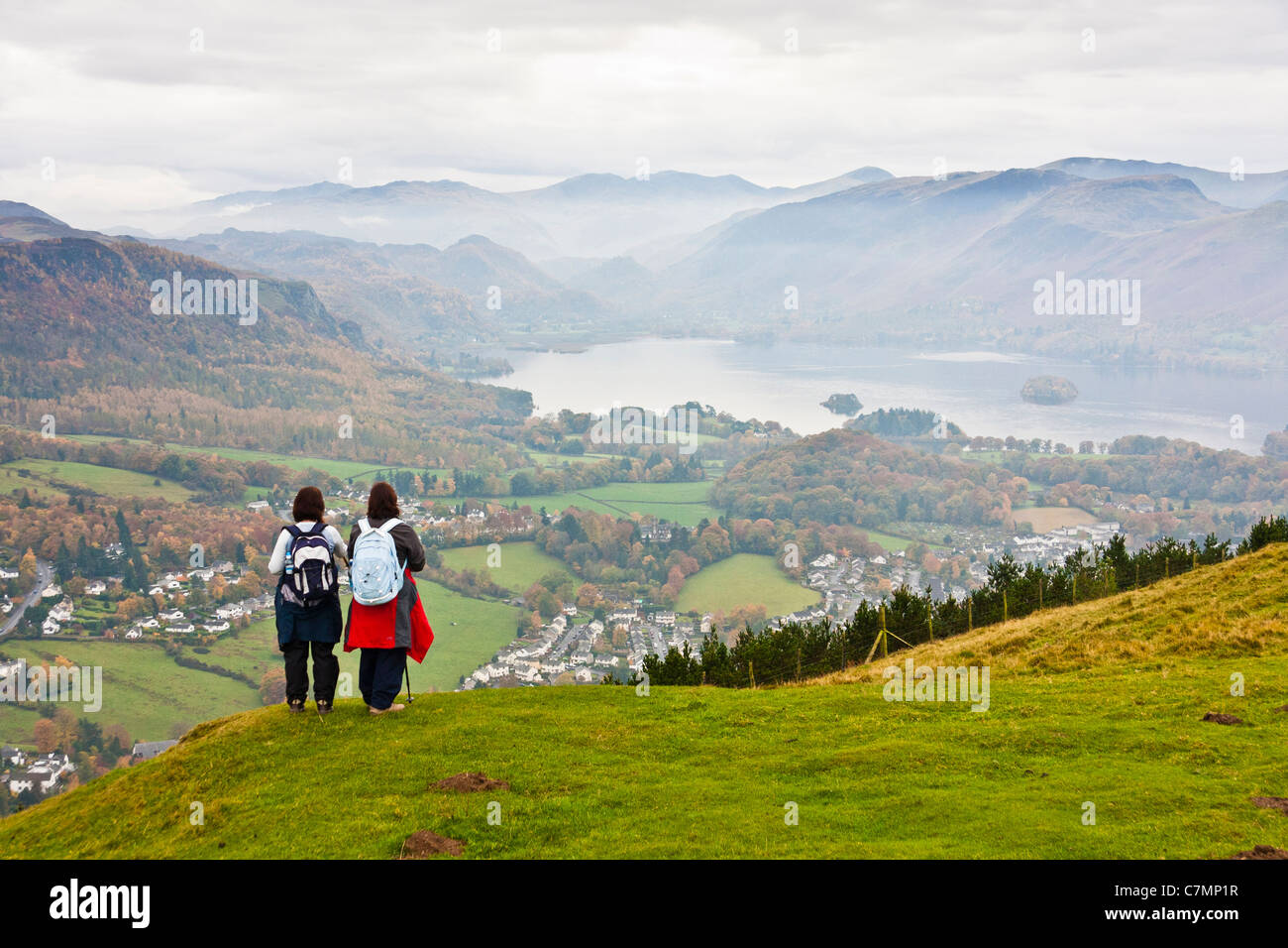 two female hikers on latrigg looking down onto derwentwater.landscape format.copy space. Stock Photo