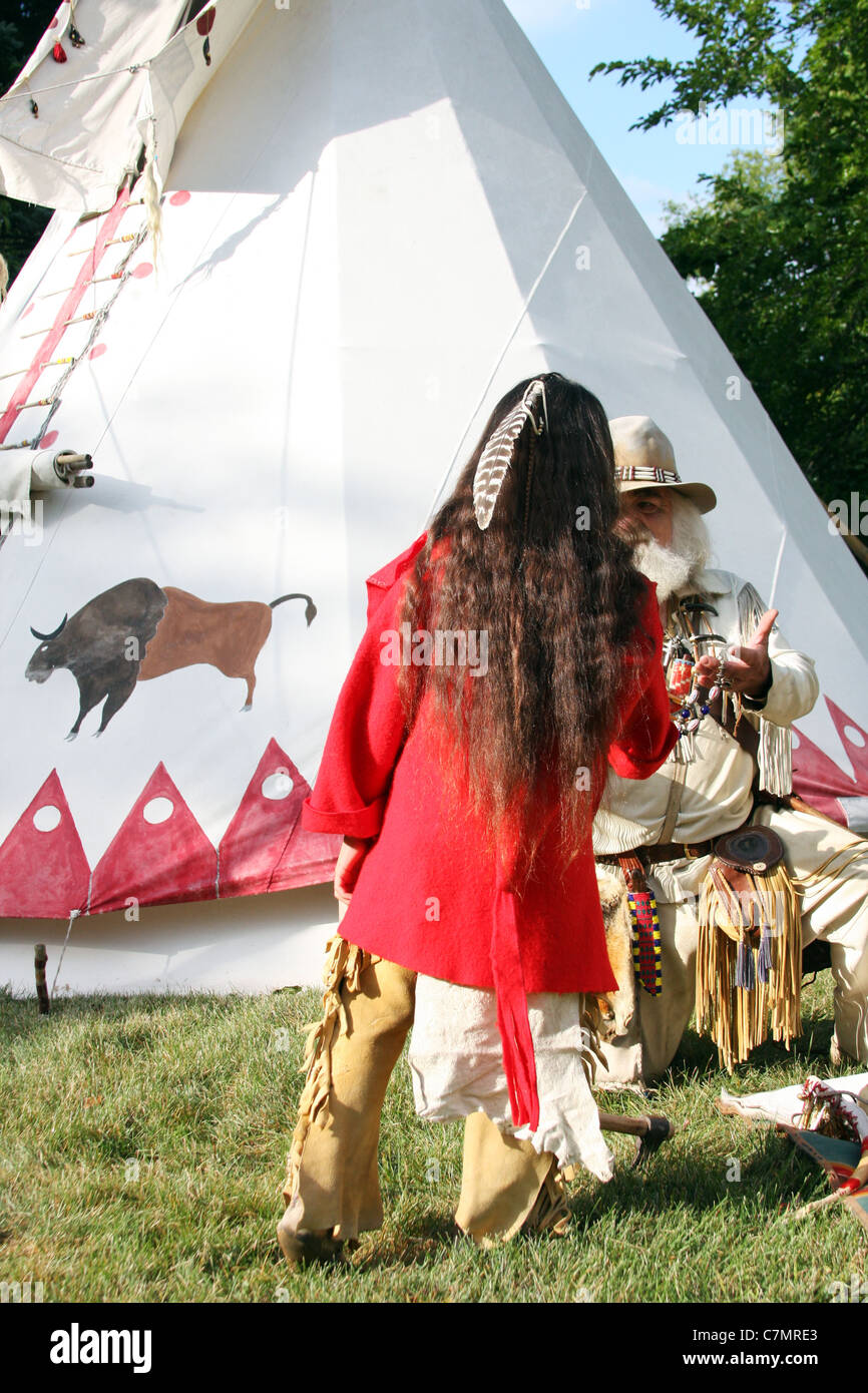 Native American Indian boy trading with a mountainman in front of a tipi Stock Photo