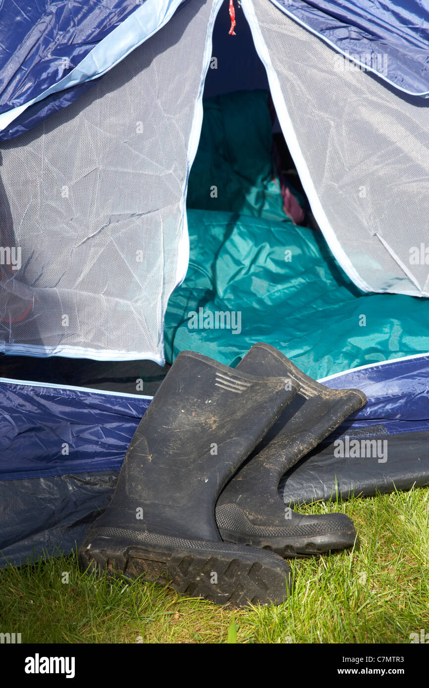 dirty wellington boots lying in front of an open tent door Stock Photo