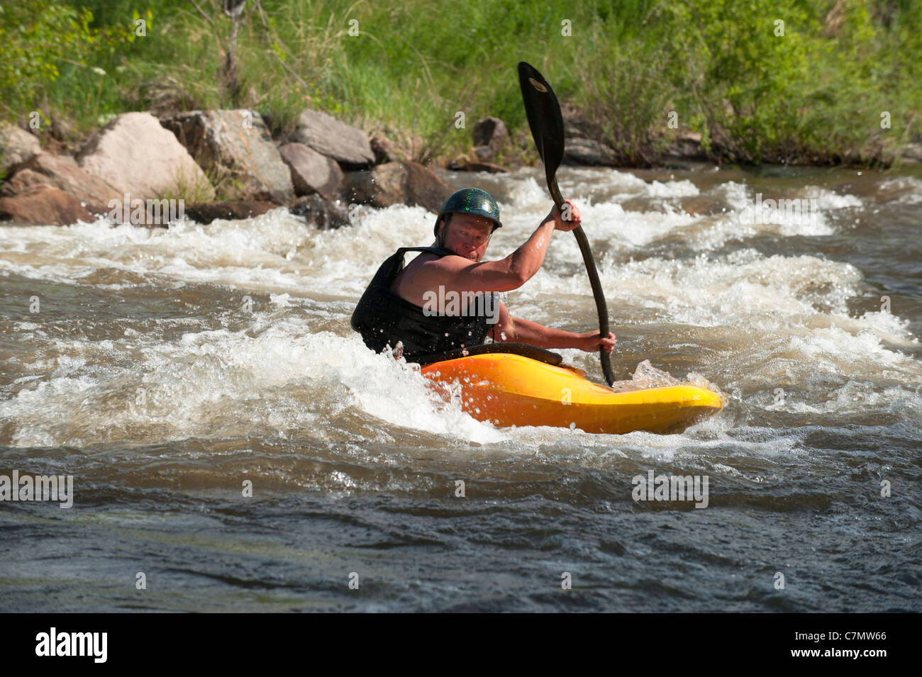 A whitewater kayaker enjoys Golden, Colorado's Clear Creek Whitewater Park Stock Photo