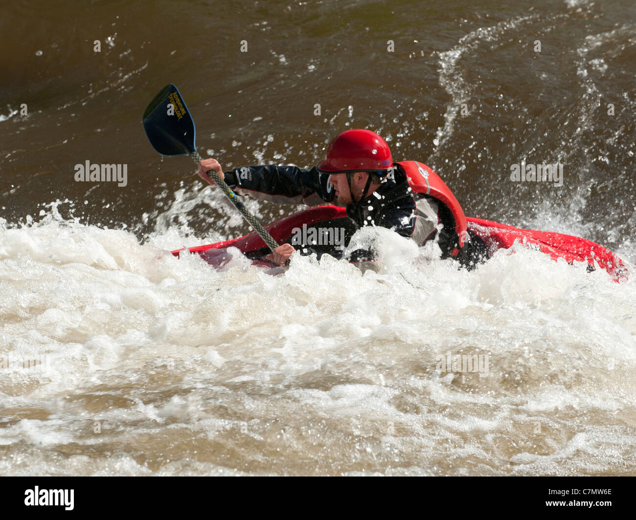 A whitewater kayaker enjoys Golden, Colorado's Clear Creek Whitewater Park Stock Photo