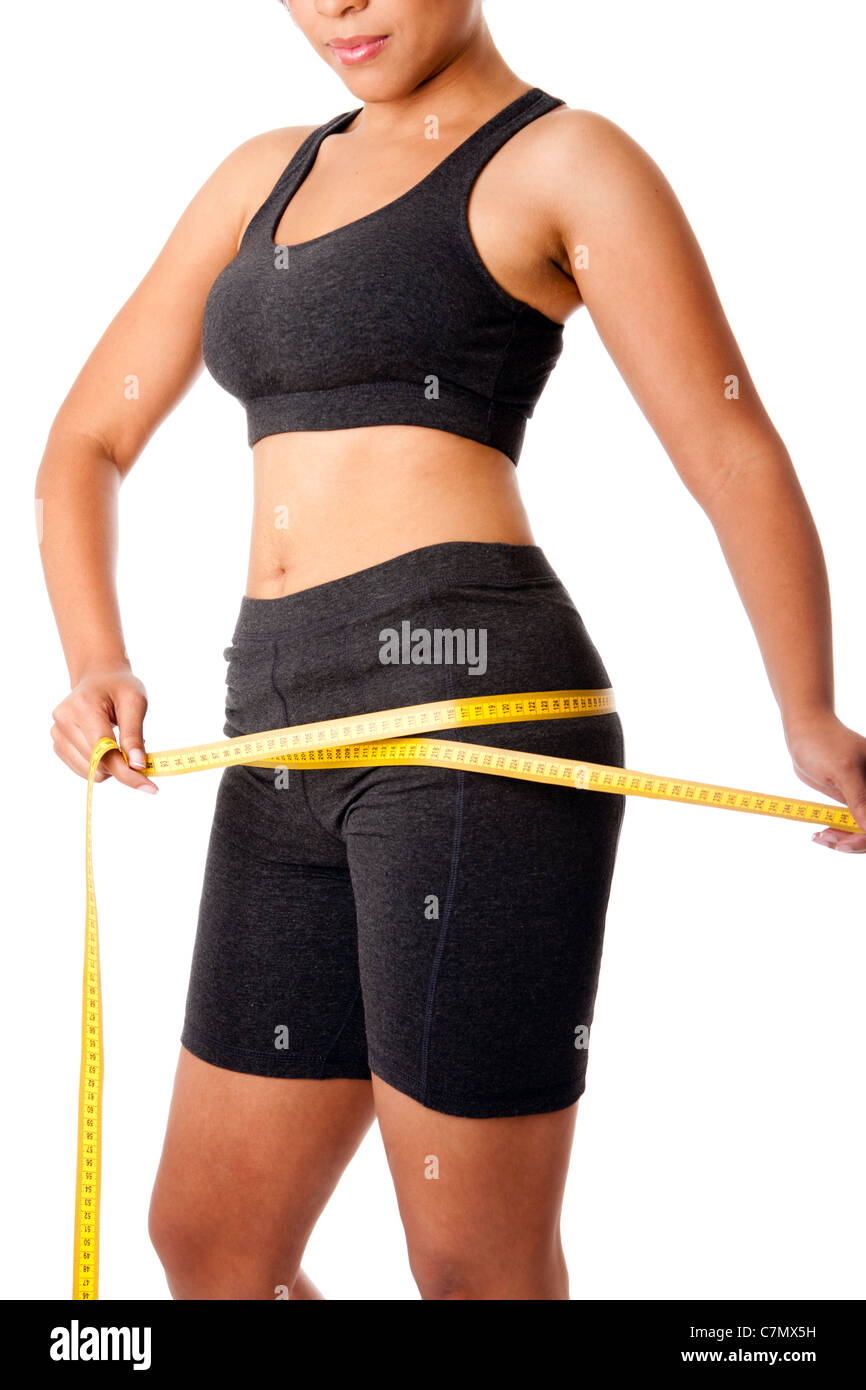 Woman dressed in grey measuring size of thigh, healthy lifestyles weightloss concept, isolated. Stock Photo
