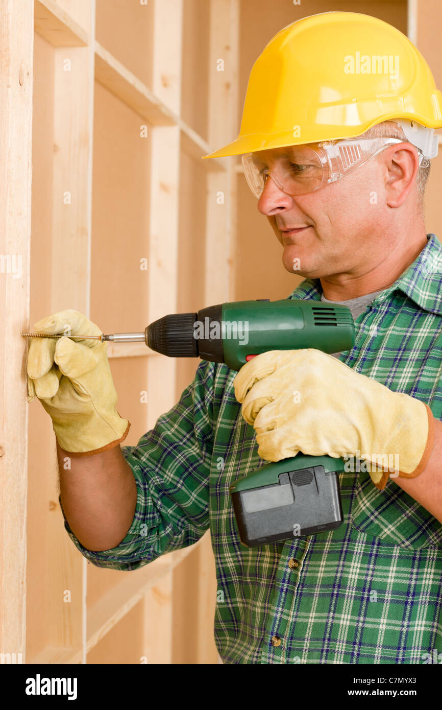 Handyman home improvement working on wall renovations using screwdriver Stock Photo