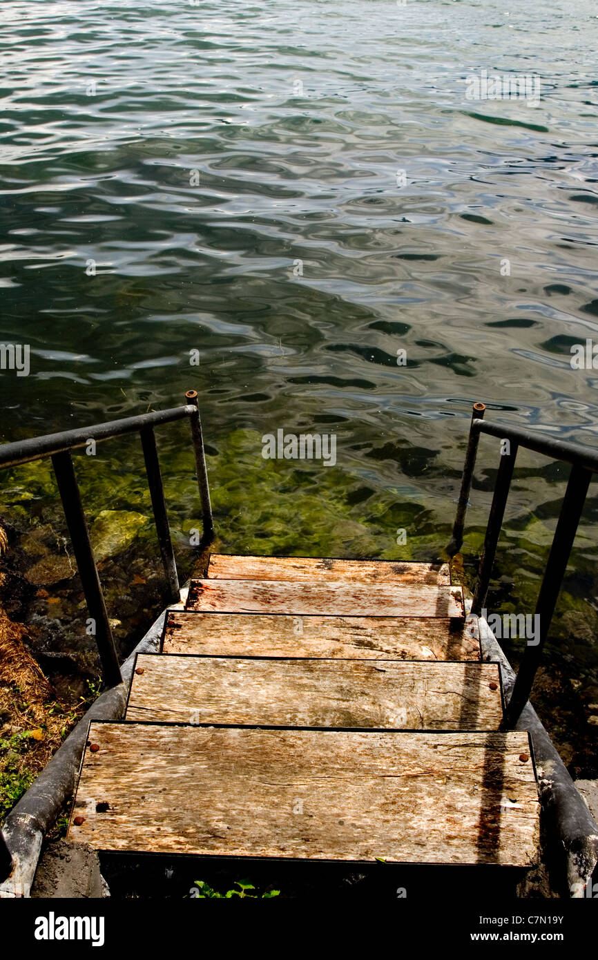 Old grungy stairs leading down to a lake Stock Photo