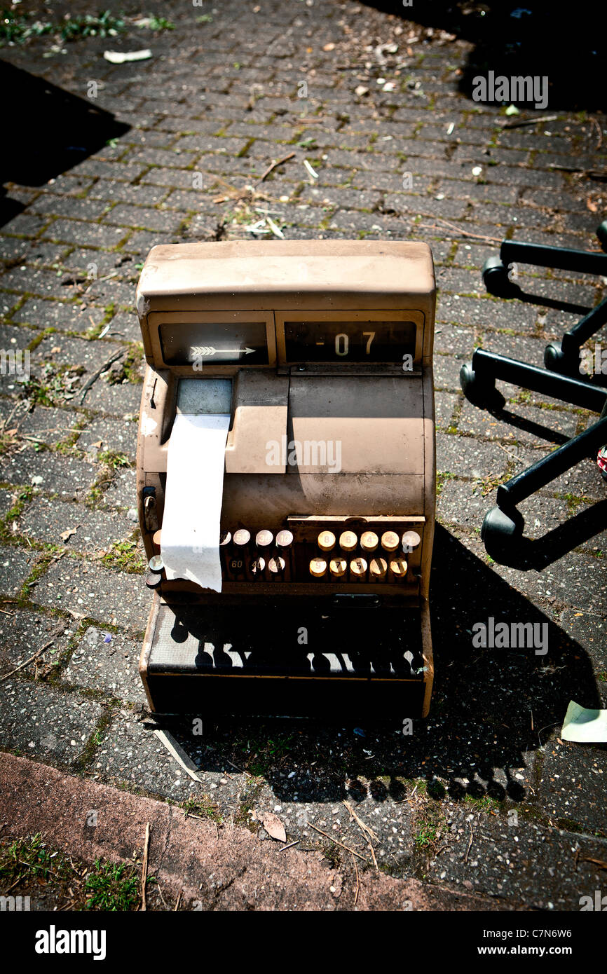 Old cash till dumped on pavement Stock Photo