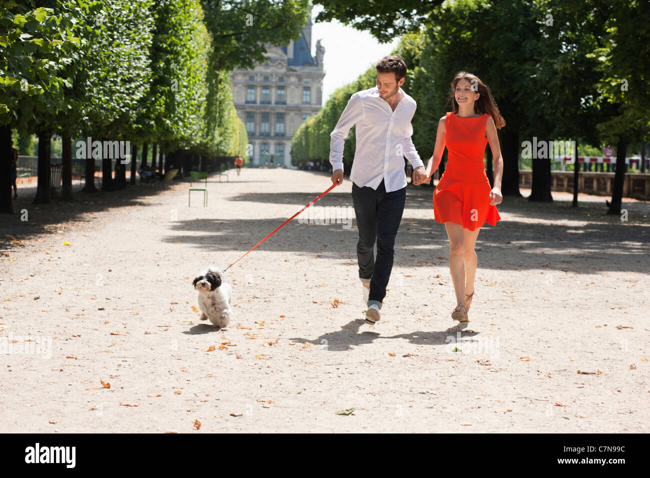 Couple running in a garden with a puppy, Terrasse De l'Orangerie