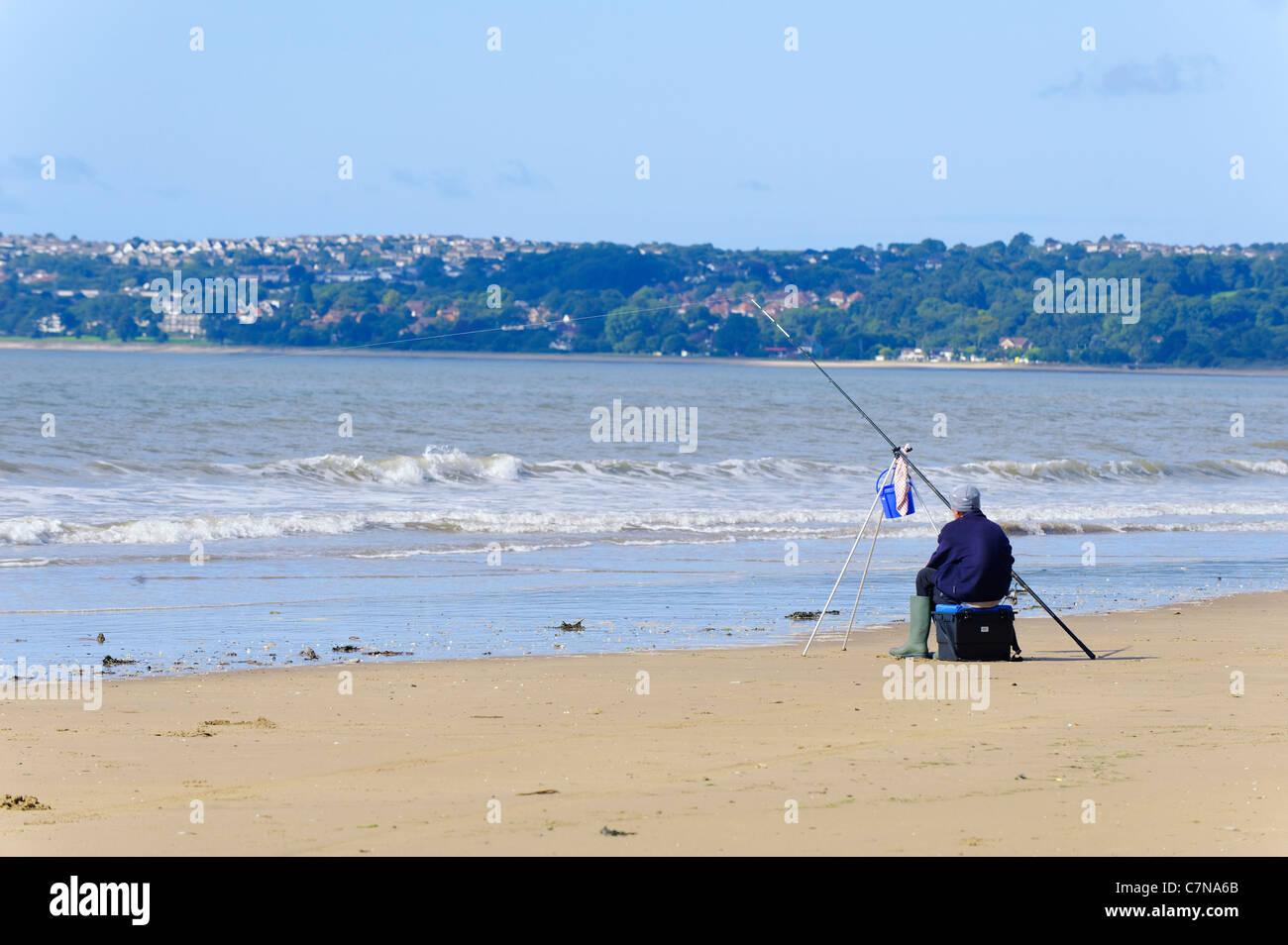 Man fishing in the bay from Swansea beach Stock Photo