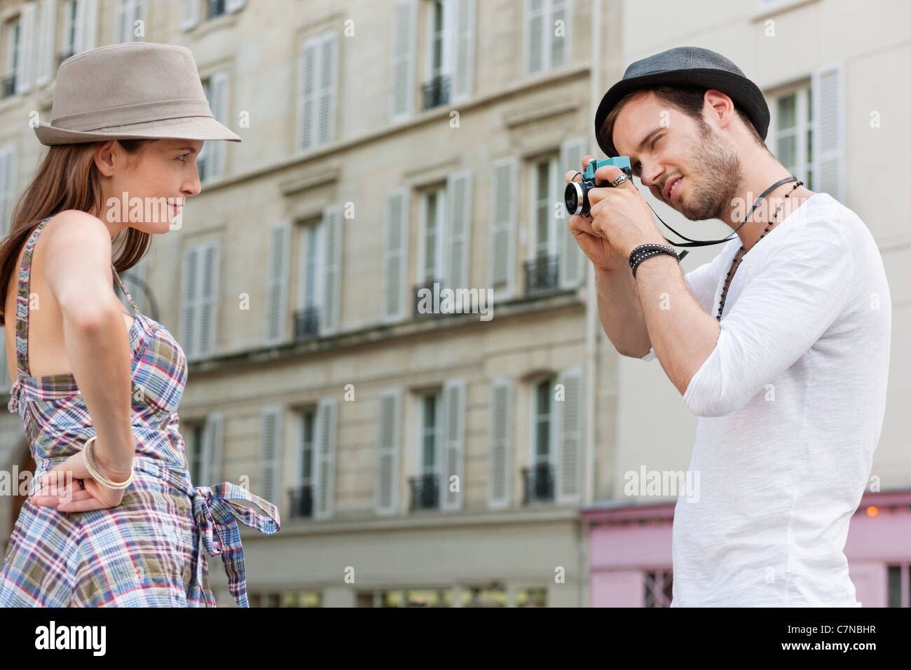 Man taking a picture of a woman standing with her hand on her hip, Paris, Ile-de-France, France Stock Photo