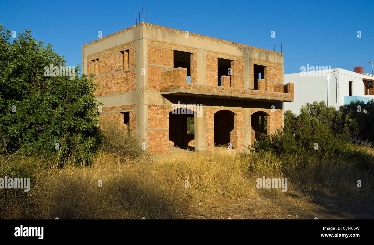An unfinished and abandoned block of holiday apartments due to the Greek financial crisis in Agios Nikolaos, Crete Stock Photo