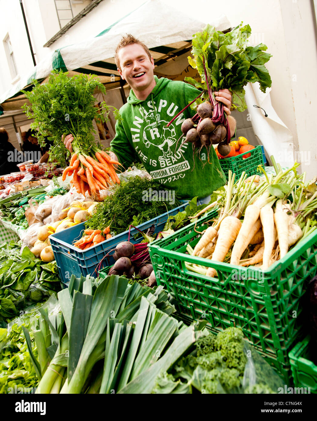 A young man selling Organic locally grown vegetables on sale at Aberystwyth Food Fair, September 2011, Wales UK Stock Photo