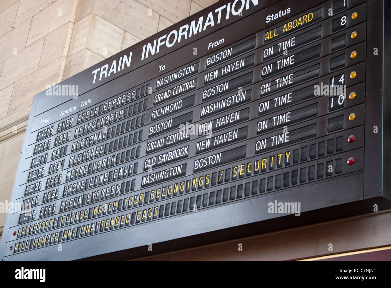 A schedule board in a train station with information telling the time and destinations for travelers. Stock Photo