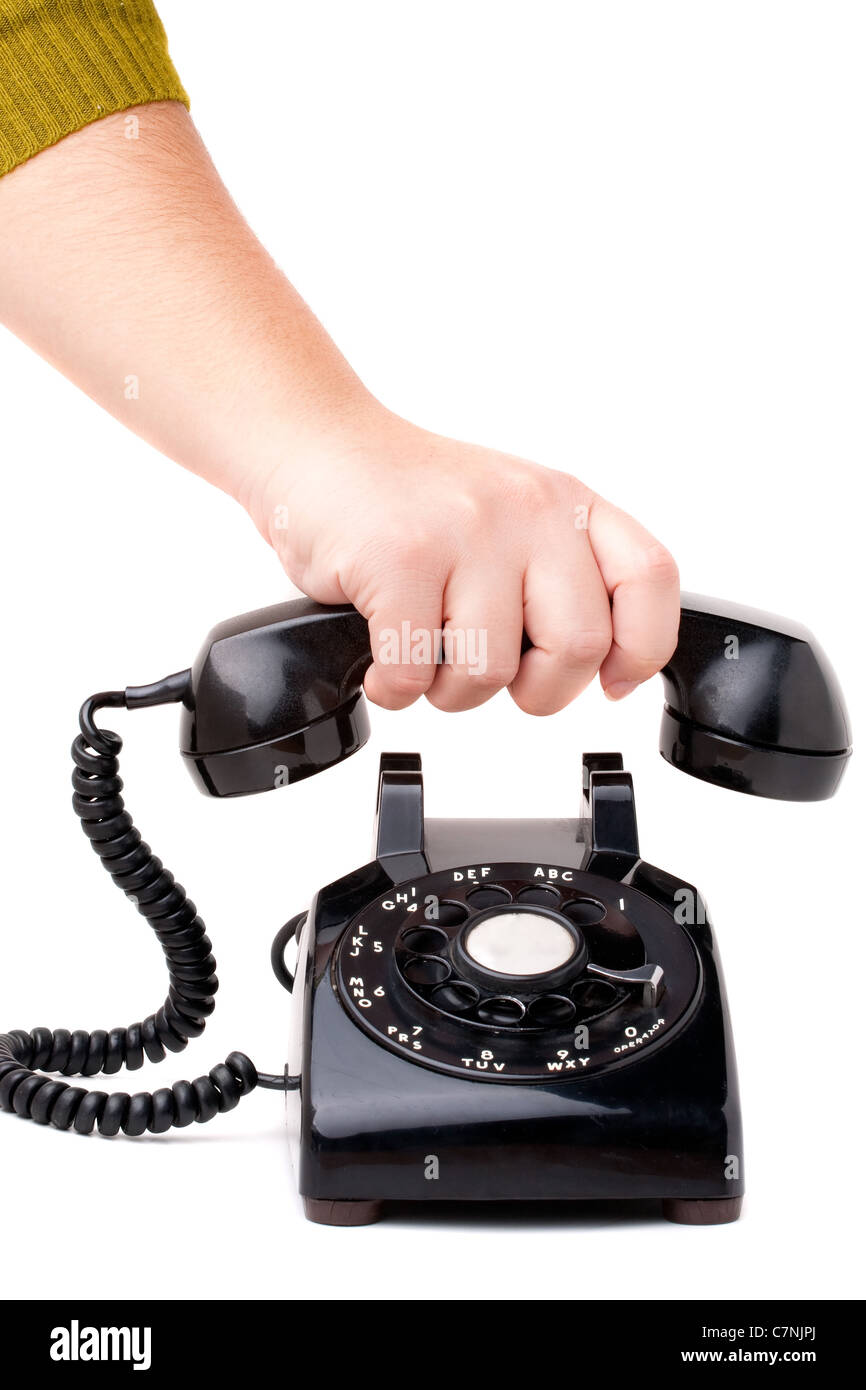 A hand hanging up the handset of an old black vintage rotary style