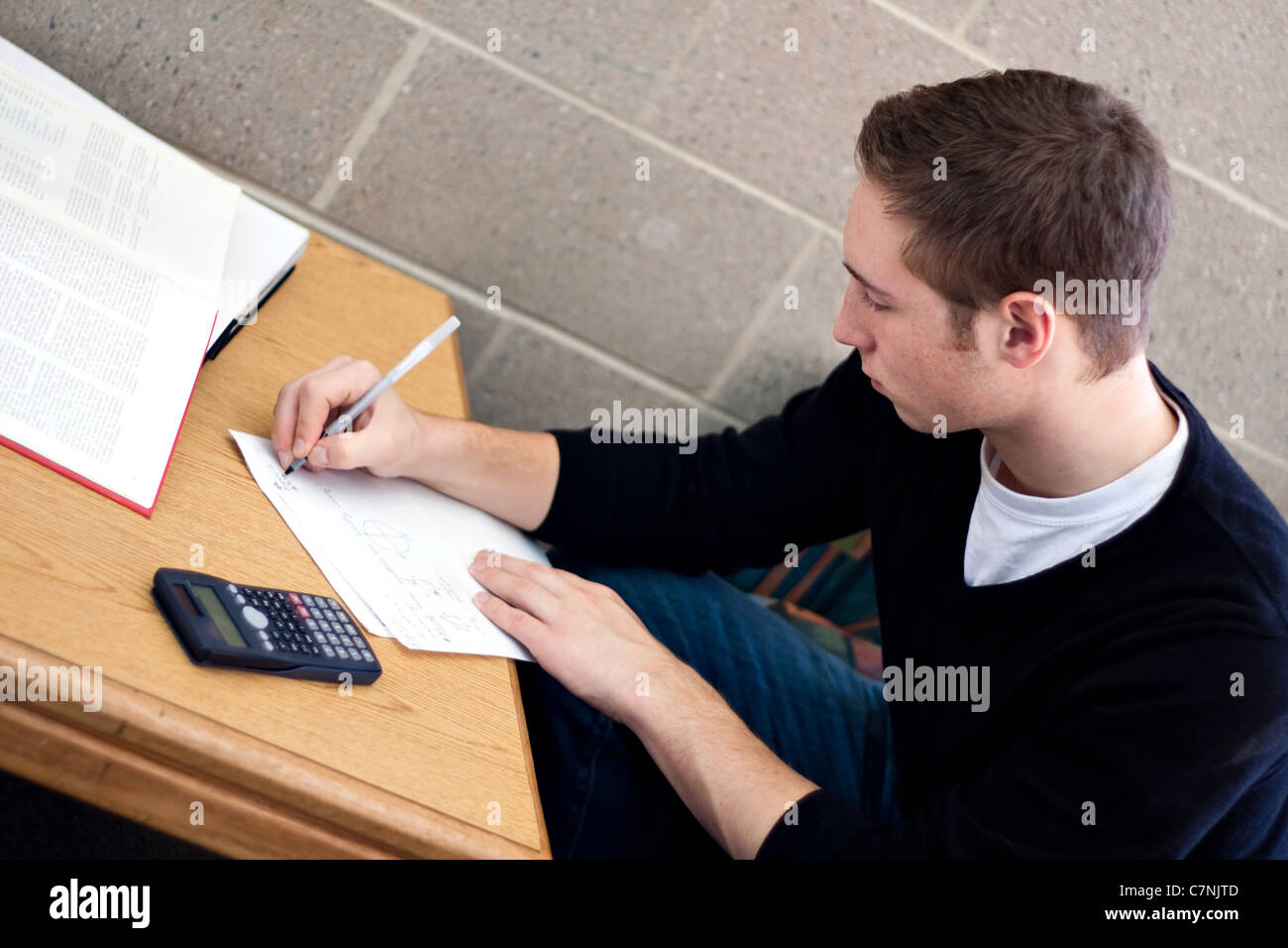 A young high school or college student working on his math homework. Stock Photo