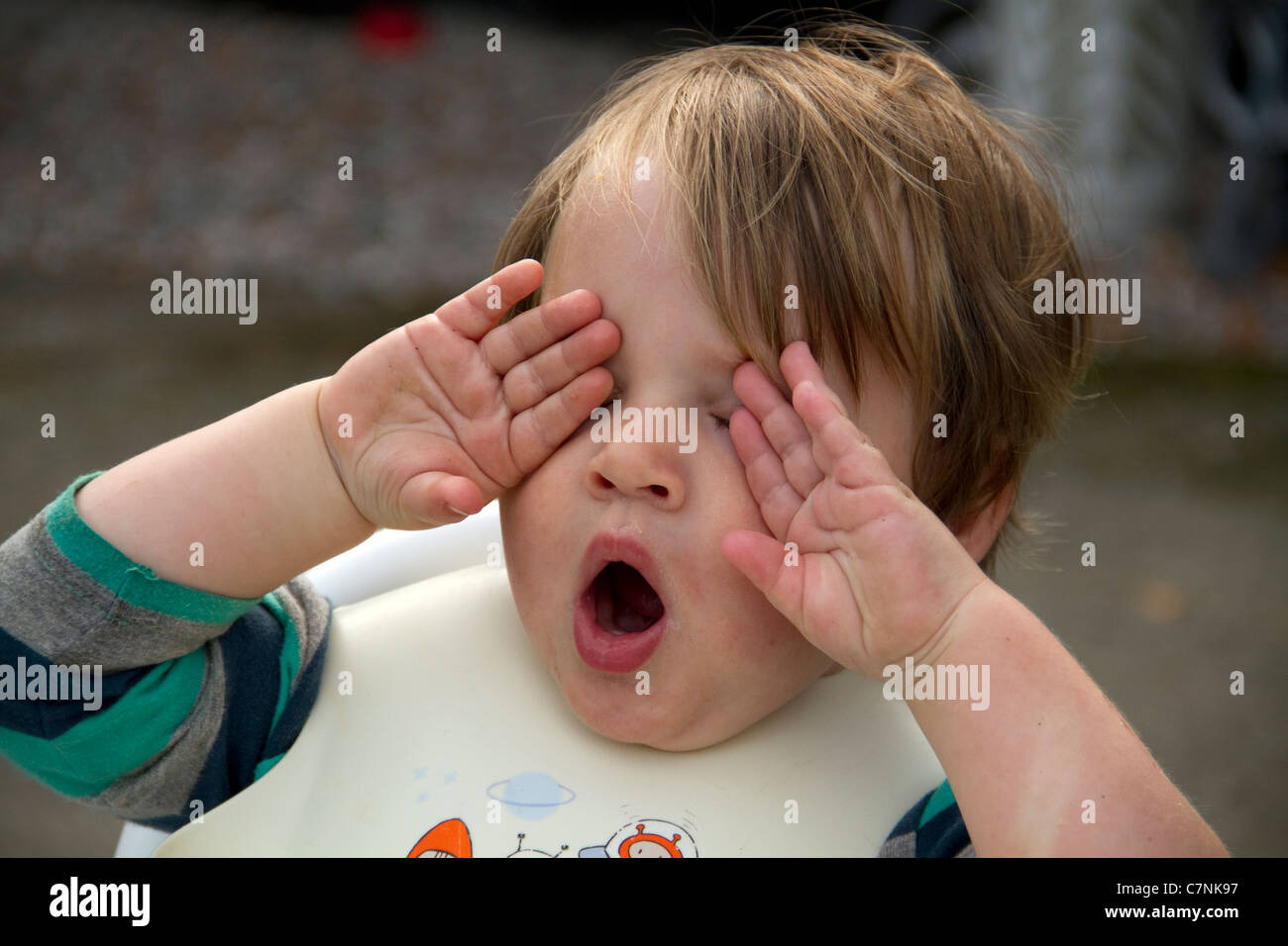 Very tired toddler yawning outside after food Stock Photo