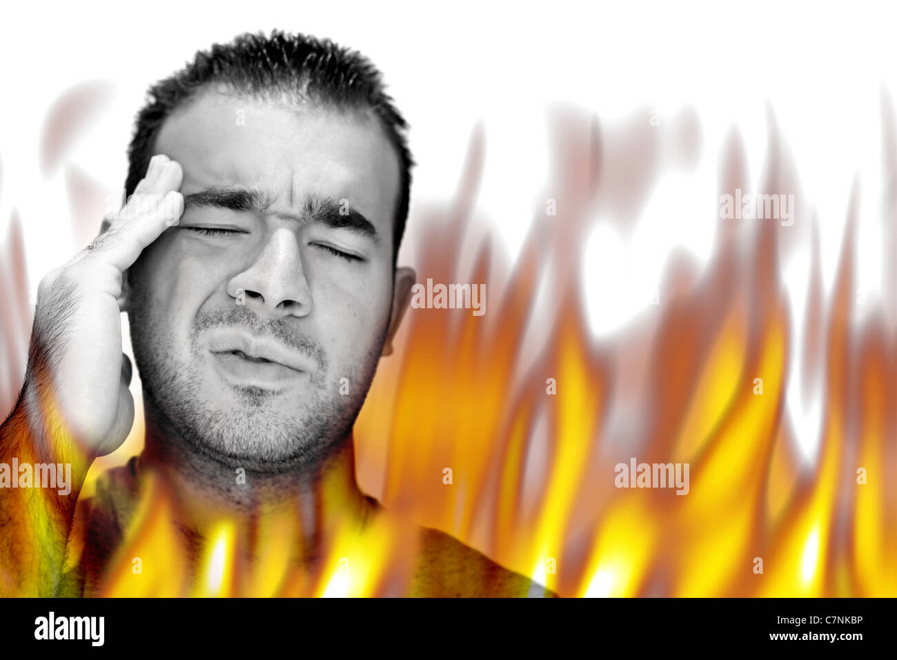 A man experiencing pain and suffering with hot fiery flames burning around him. Stock Photo