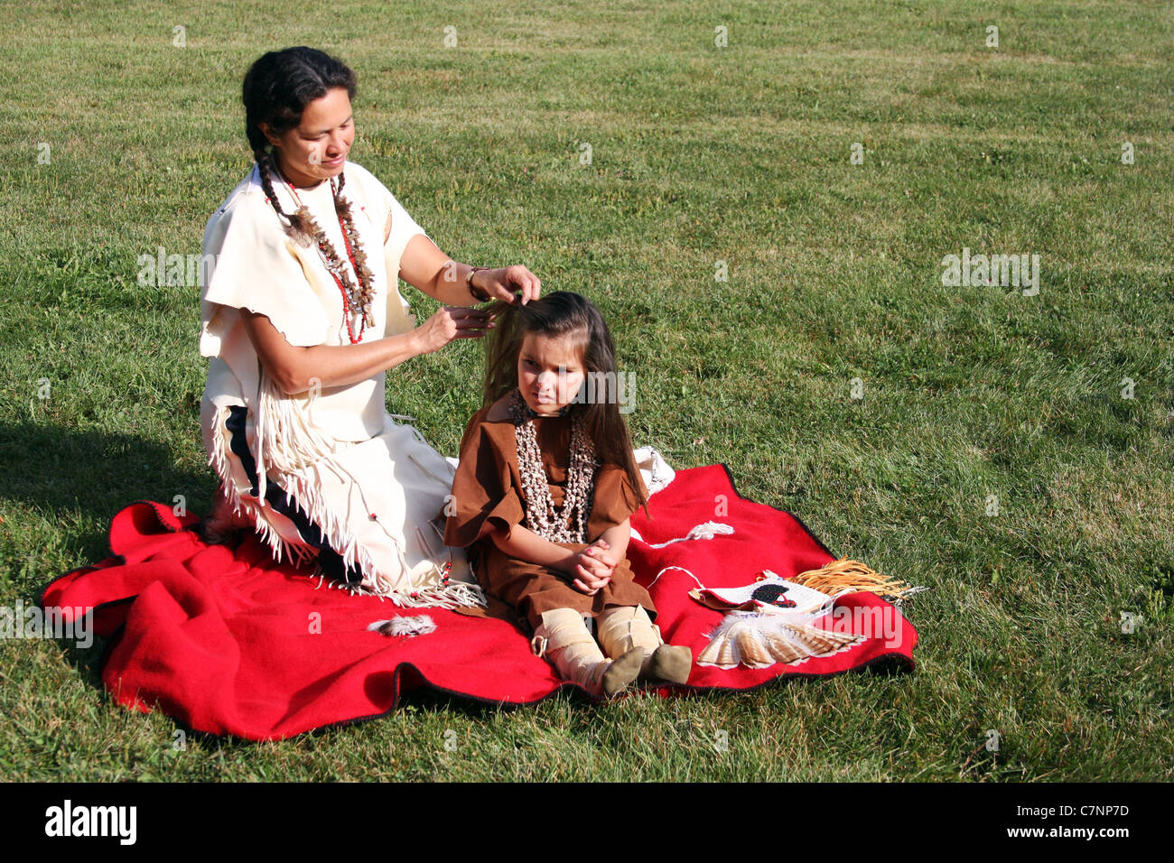 A Native American Indian woman braiding her childs hair Stock Photo - Alamy