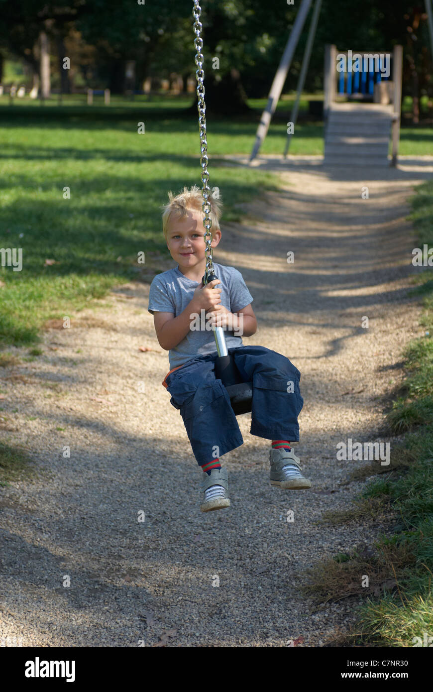 A young child boy playing on a playground lift outdoors Stock Photo - Alamy