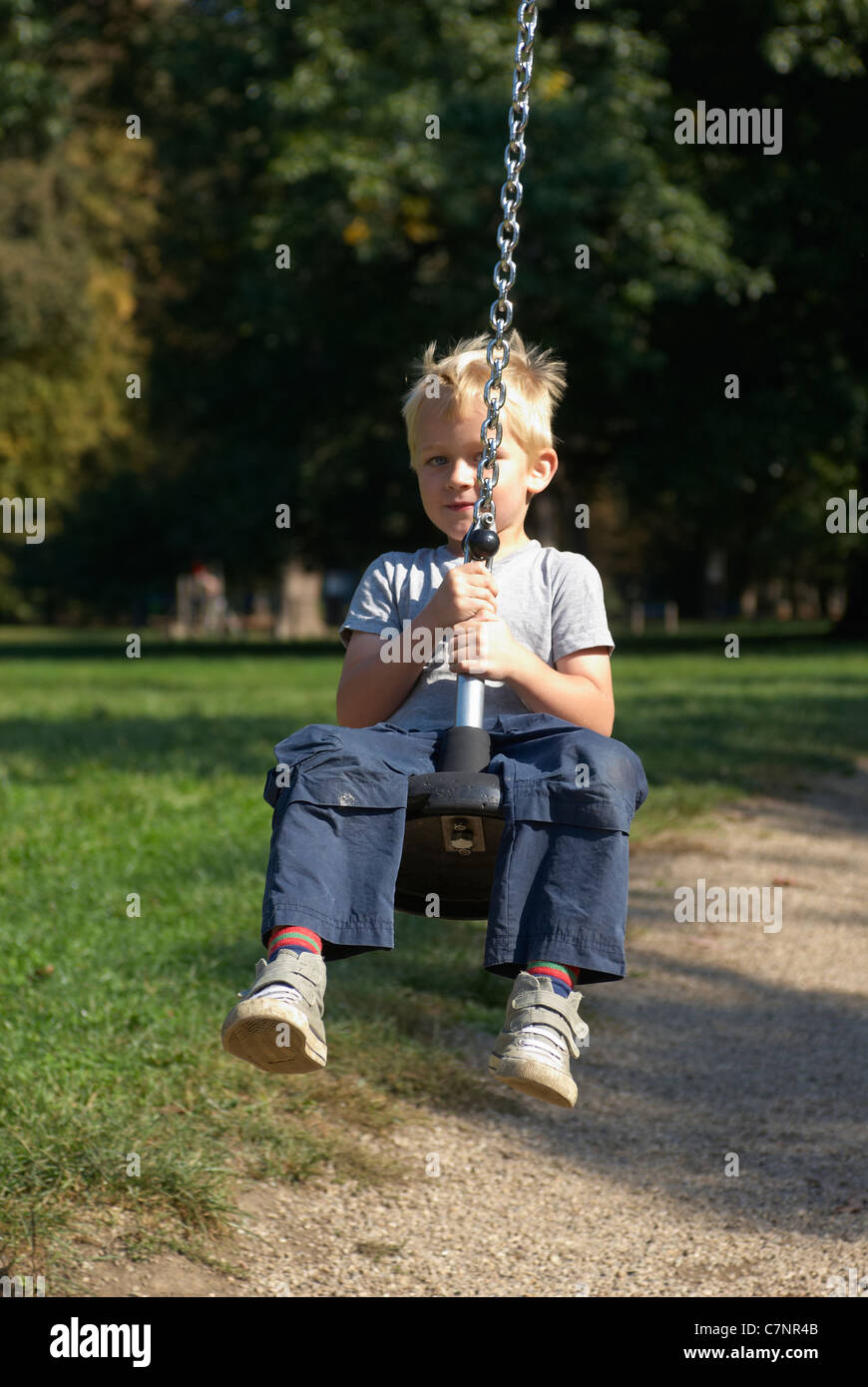 A young child boy playing on a playground lift outdoors Stock Photo - Alamy