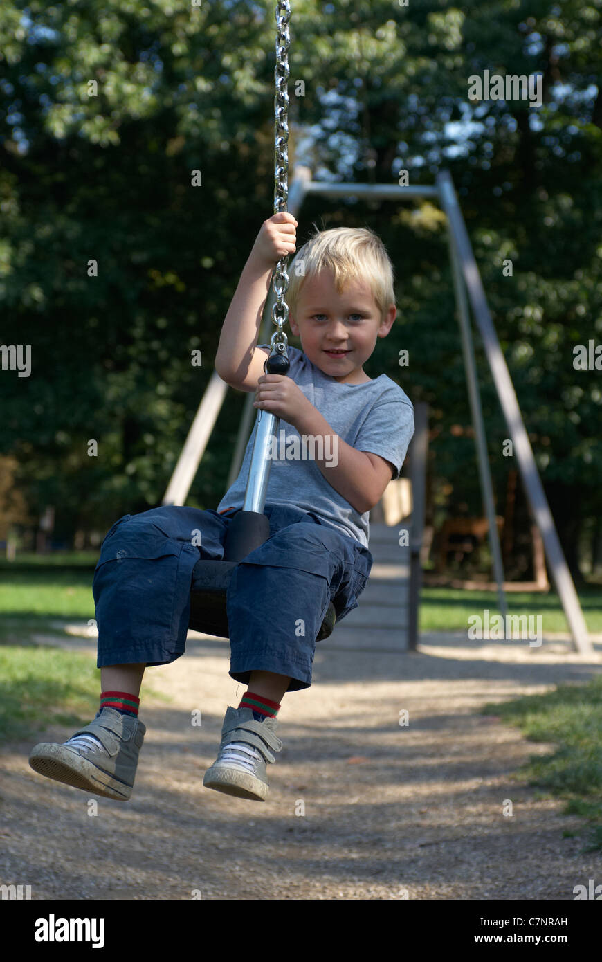 A young child boy playing on a playground lift outdoors Stock Photo - Alamy