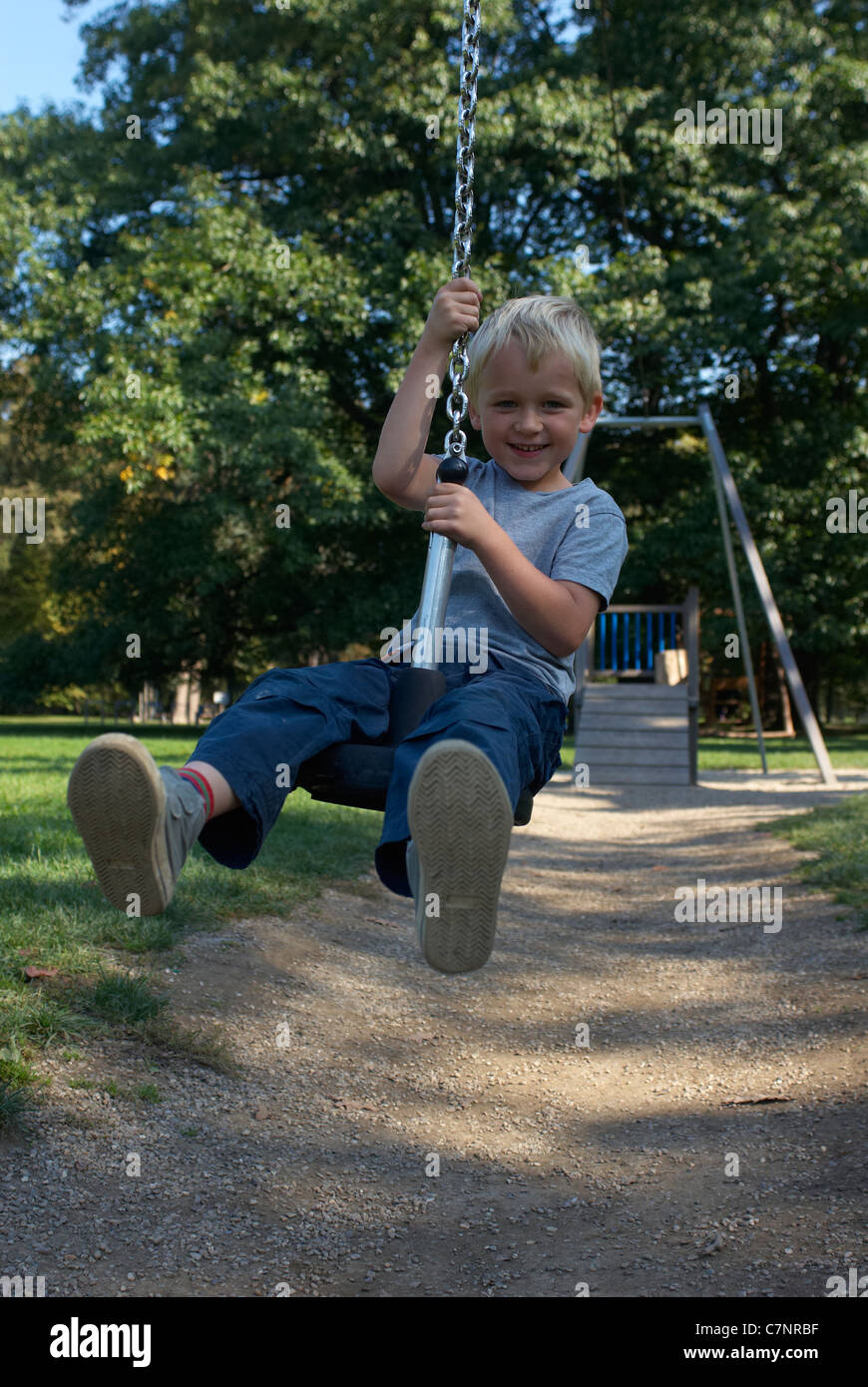 A young child boy playing on a playground lift outdoors Stock Photo - Alamy