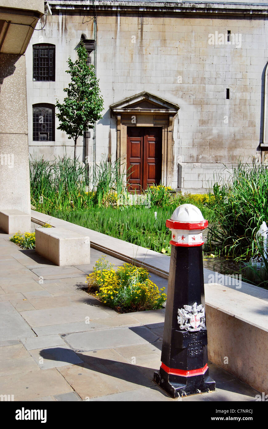 Stone benches and pond in front of St. Laurence Jury, civic church of the Corporation of London, restored by Wren in 1677. Stock Photo