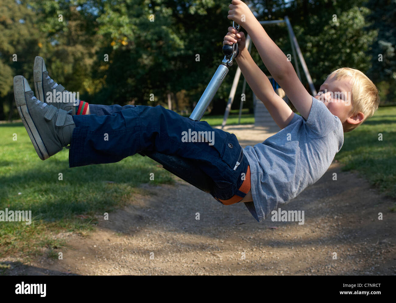 A young child boy playing on a playground lift outdoors Stock Photo - Alamy