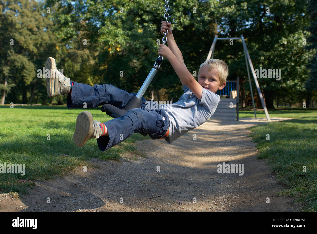 A young child boy playing on a playground lift outdoors Stock Photo - Alamy