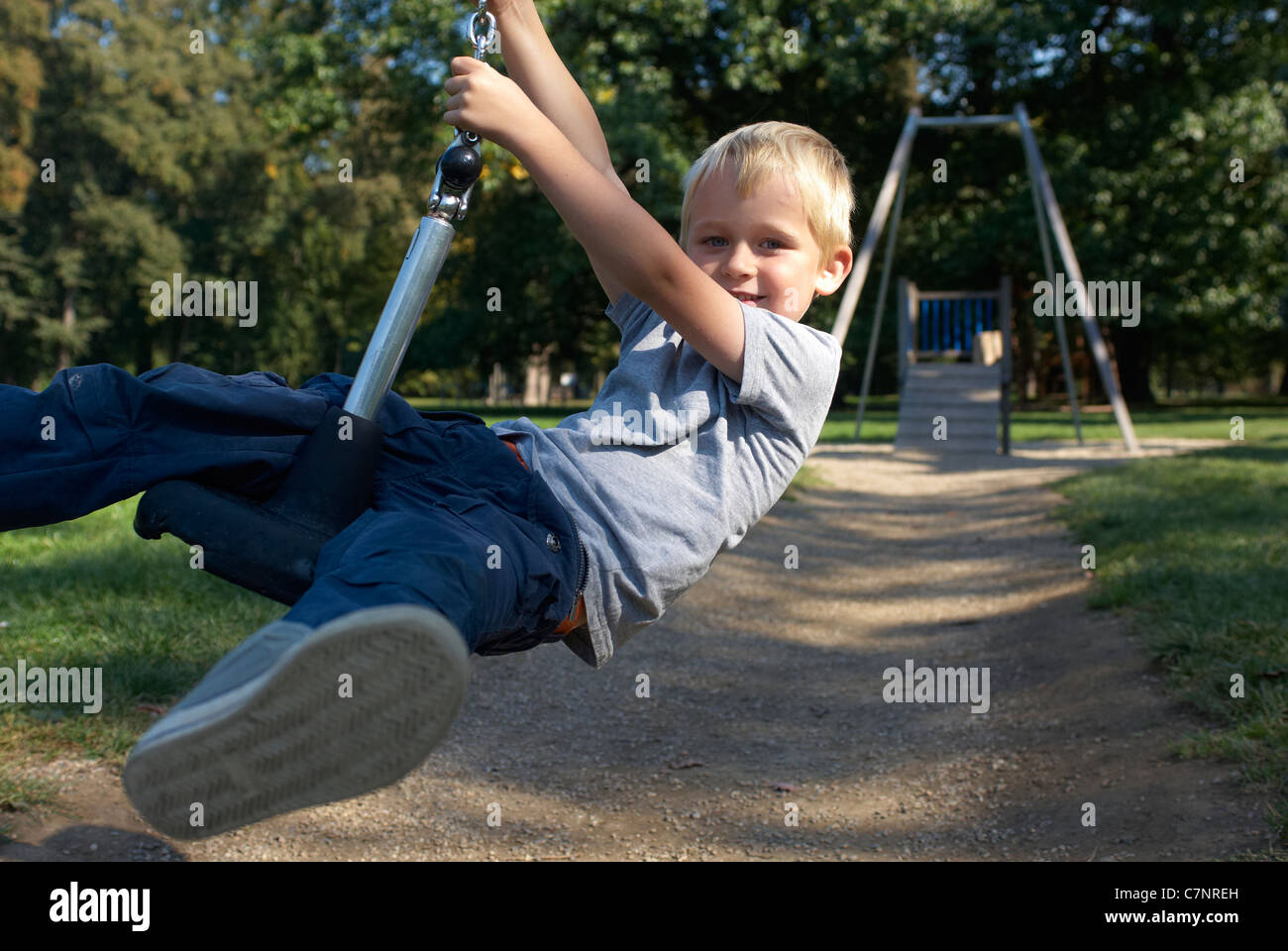 A young child boy playing on a playground lift outdoors Stock Photo - Alamy