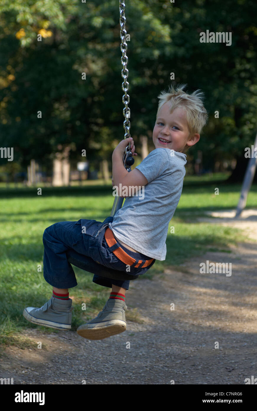 A young child boy playing on a playground lift outdoors Stock Photo - Alamy