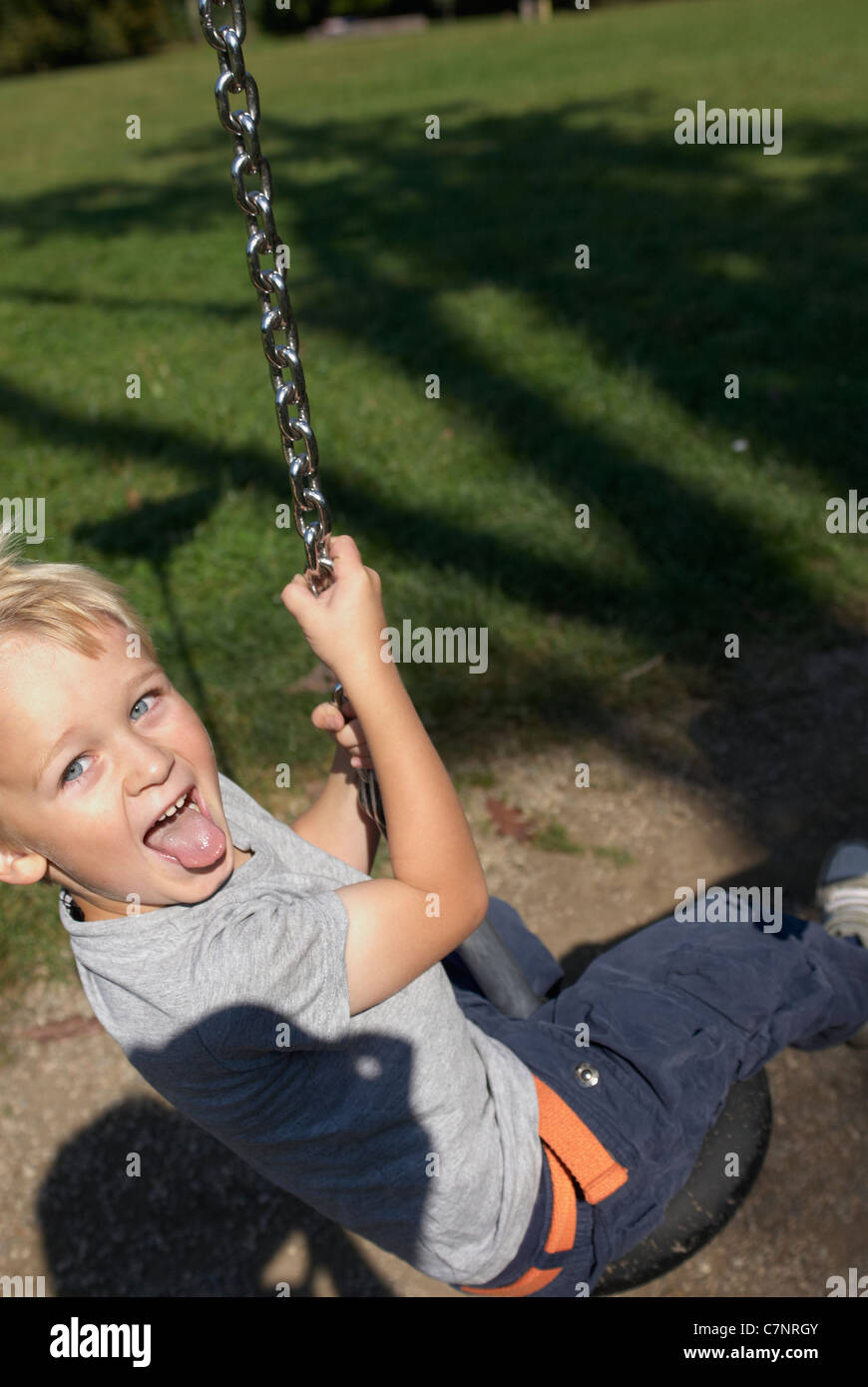 A young child boy playing on a playground lift outdoors Stock Photo - Alamy