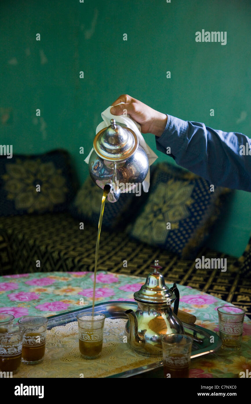 Moroccan sweet mint tea being poured into a glass from a silver teapot Stock Photo