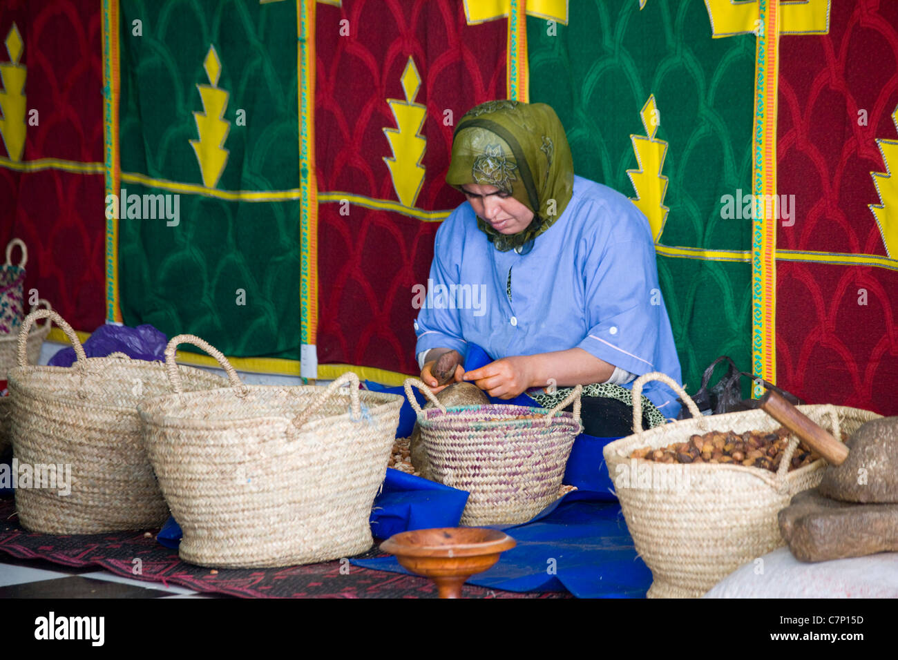 Moroccan lady shelling nuts for argan oil in Essaouira, Morocco Stock Photo