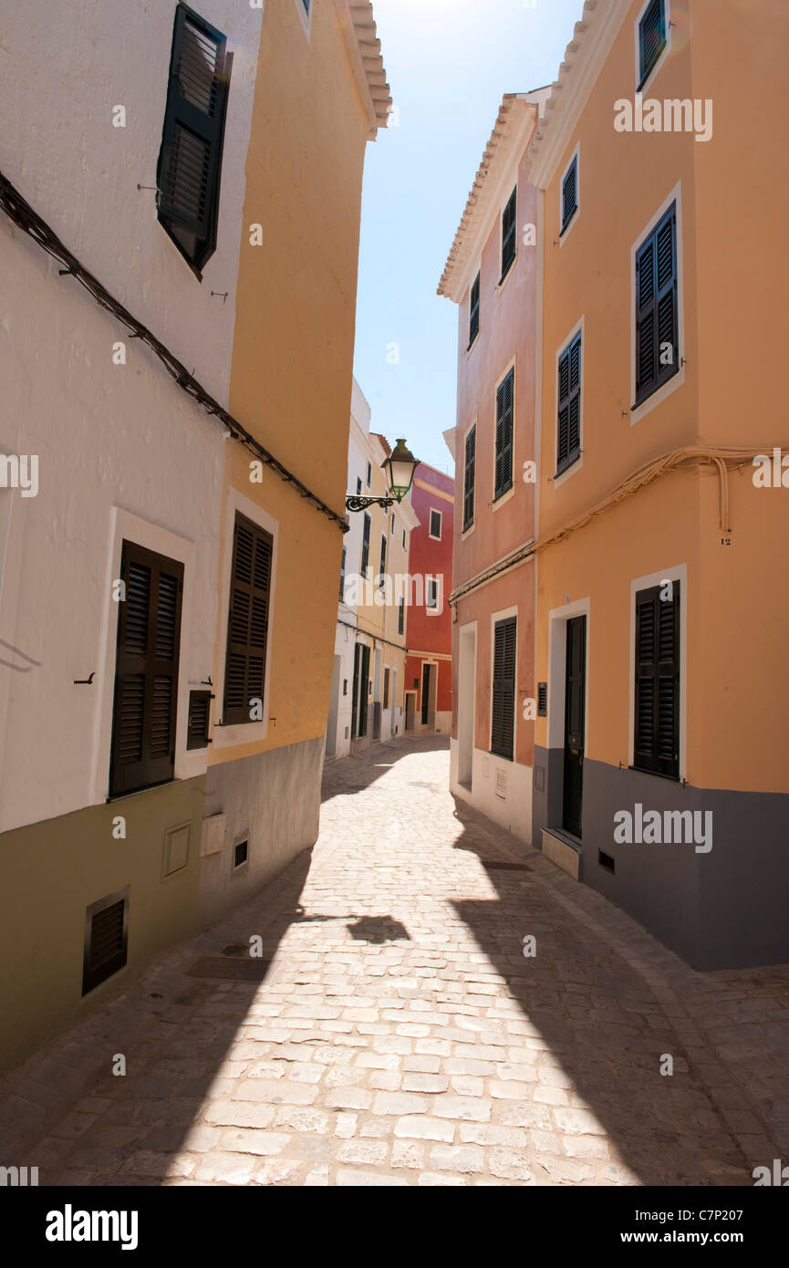 Street Alley in Minorca Spain, bright coloured building line a street. Stock Photo