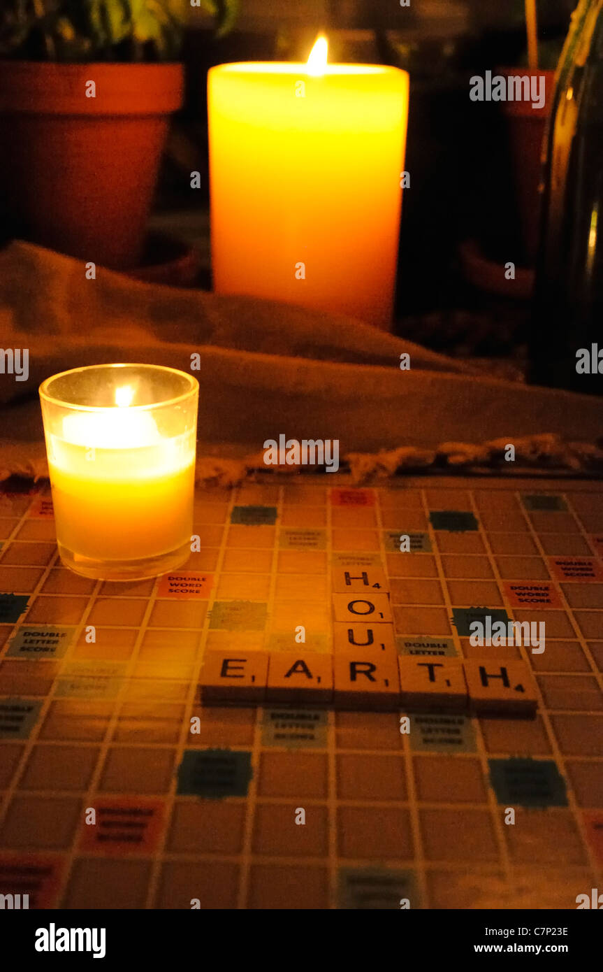 Candle lit board game spells out 'earth hour'. Stock Photo