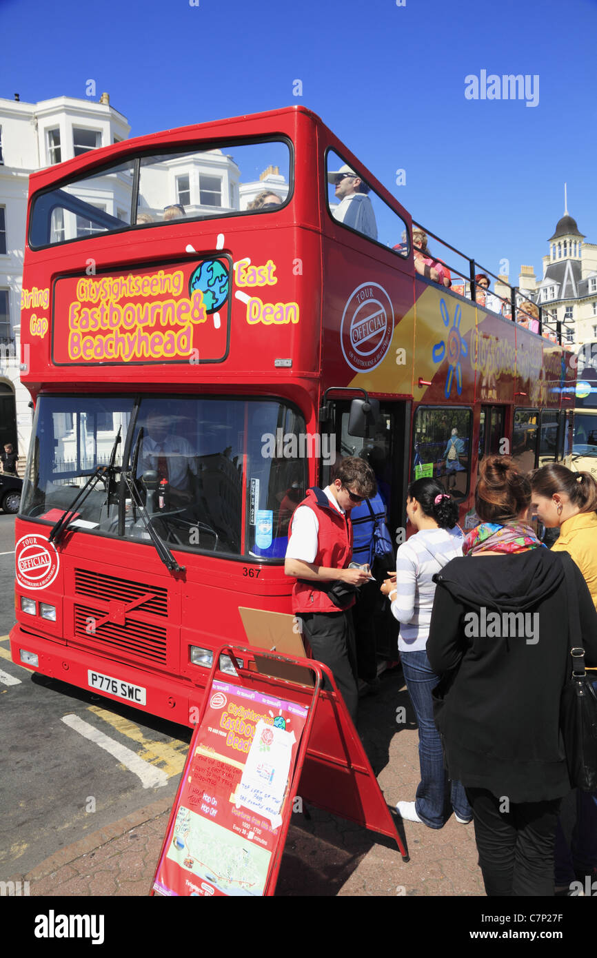 Passengers board a City Sightseeing open topped red bus in Eastbourne, East Sussex, England. Stock Photo