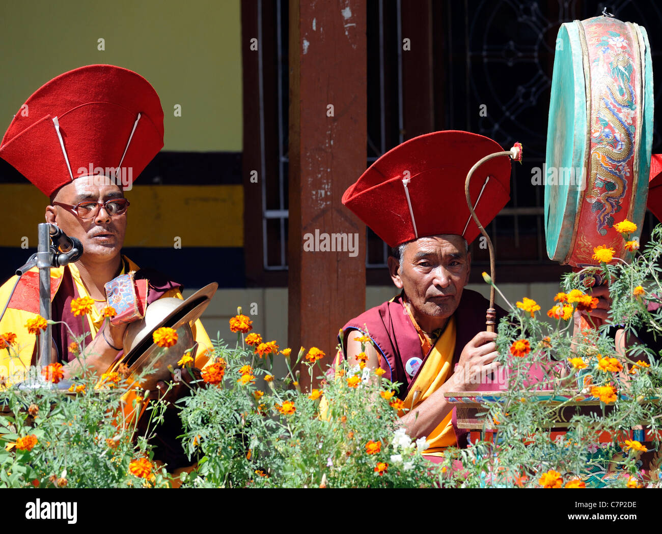 Monks chant and play bell, drum  and cymbals to accompany masked dancers at the Leh festival in the courtyard of  the Chowkhang Stock Photo