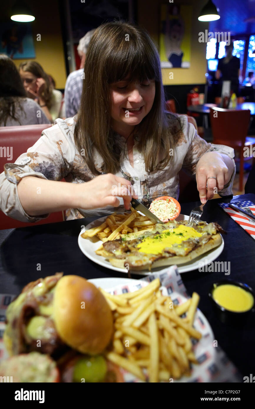 Woman tucking into unhealthy junk food Stock Photo