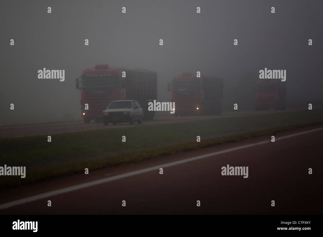 Car overtaking trucks Fog at highway, Sao Paulo State, Brazil. Stock Photo