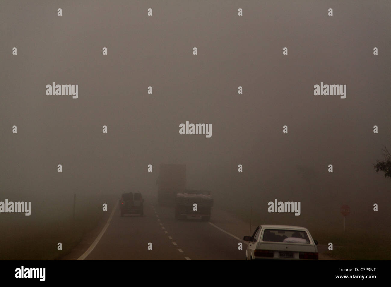 Car overtaking trucks Fog at highway, Sao Paulo State, Brazil. Stock Photo