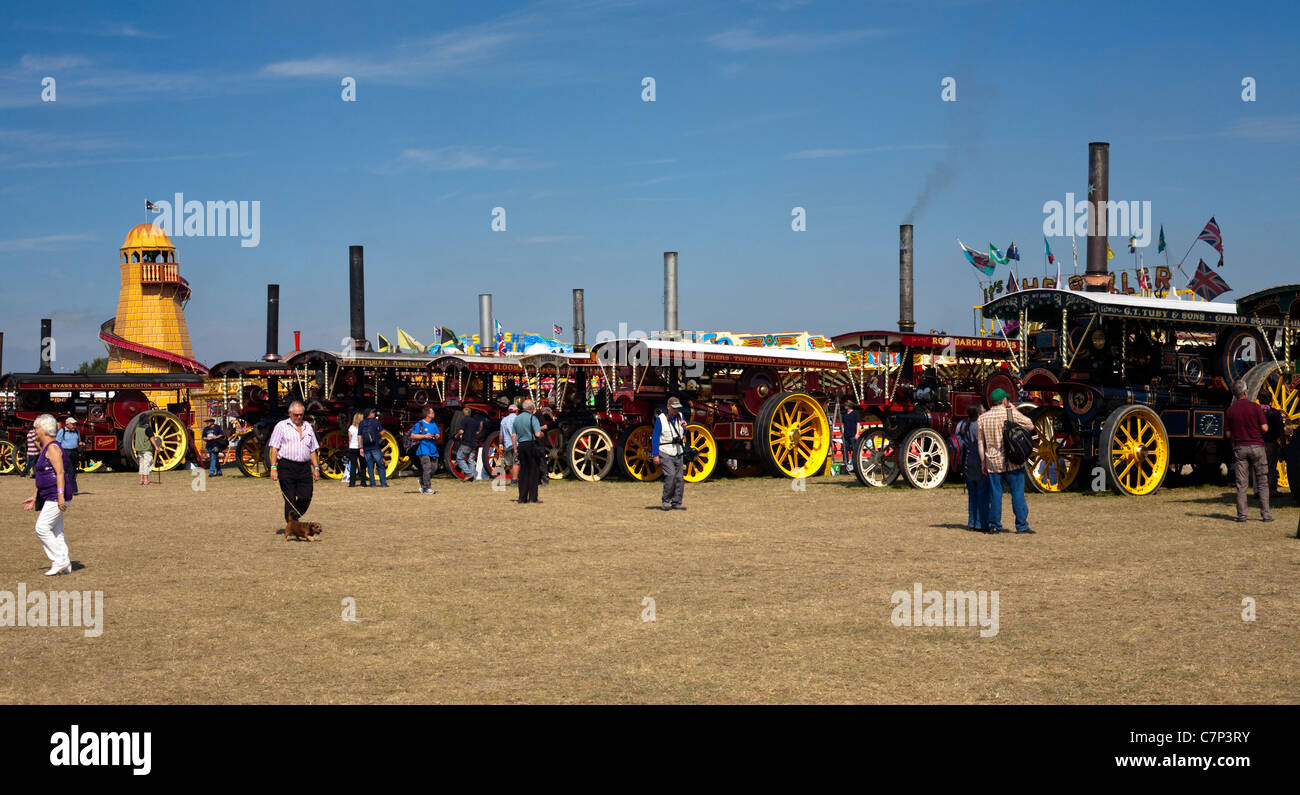 line of steam traction engines at the great dorset steam fair with people and blue sky Stock Photo