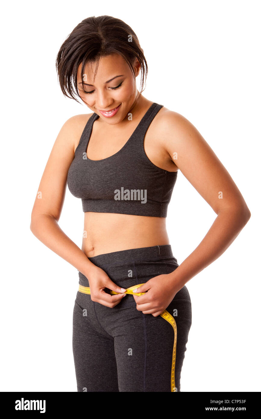 Beautiful happy toned woman weight conscious measuring her size shape around waist hips dressed sporty in grey, isolated. Stock Photo